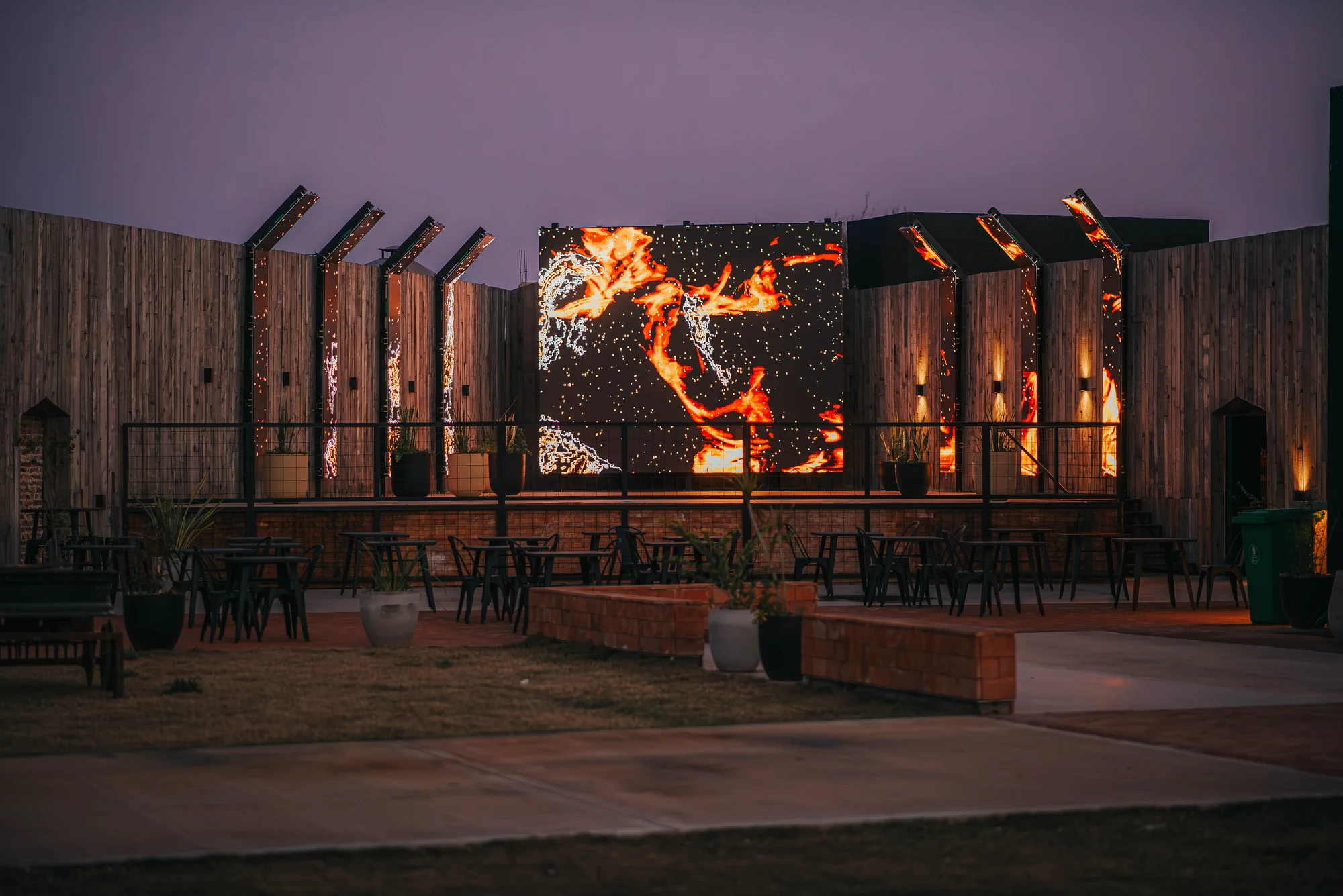 Fachada del jardín de noche con la pantalla de fuego
