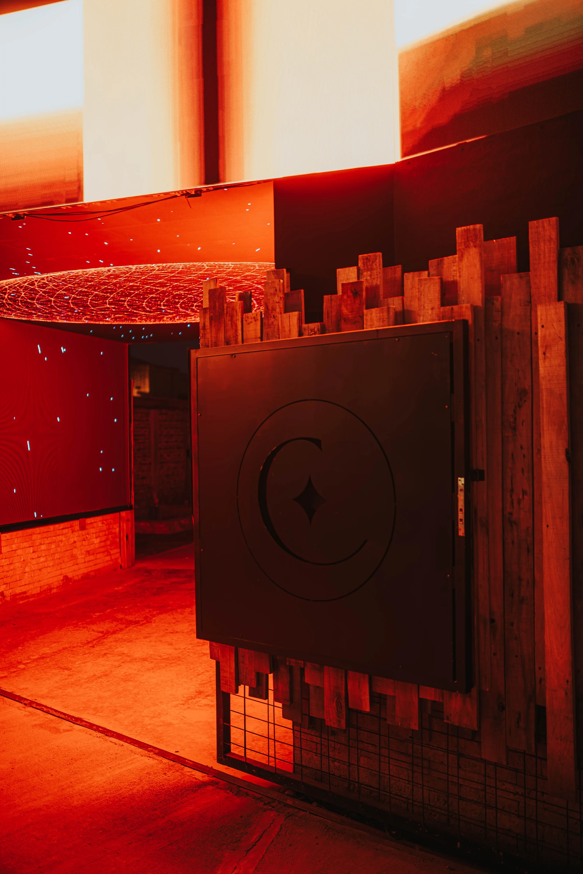 La entrada con la puerta del sello de Capricho iluminada en rojo