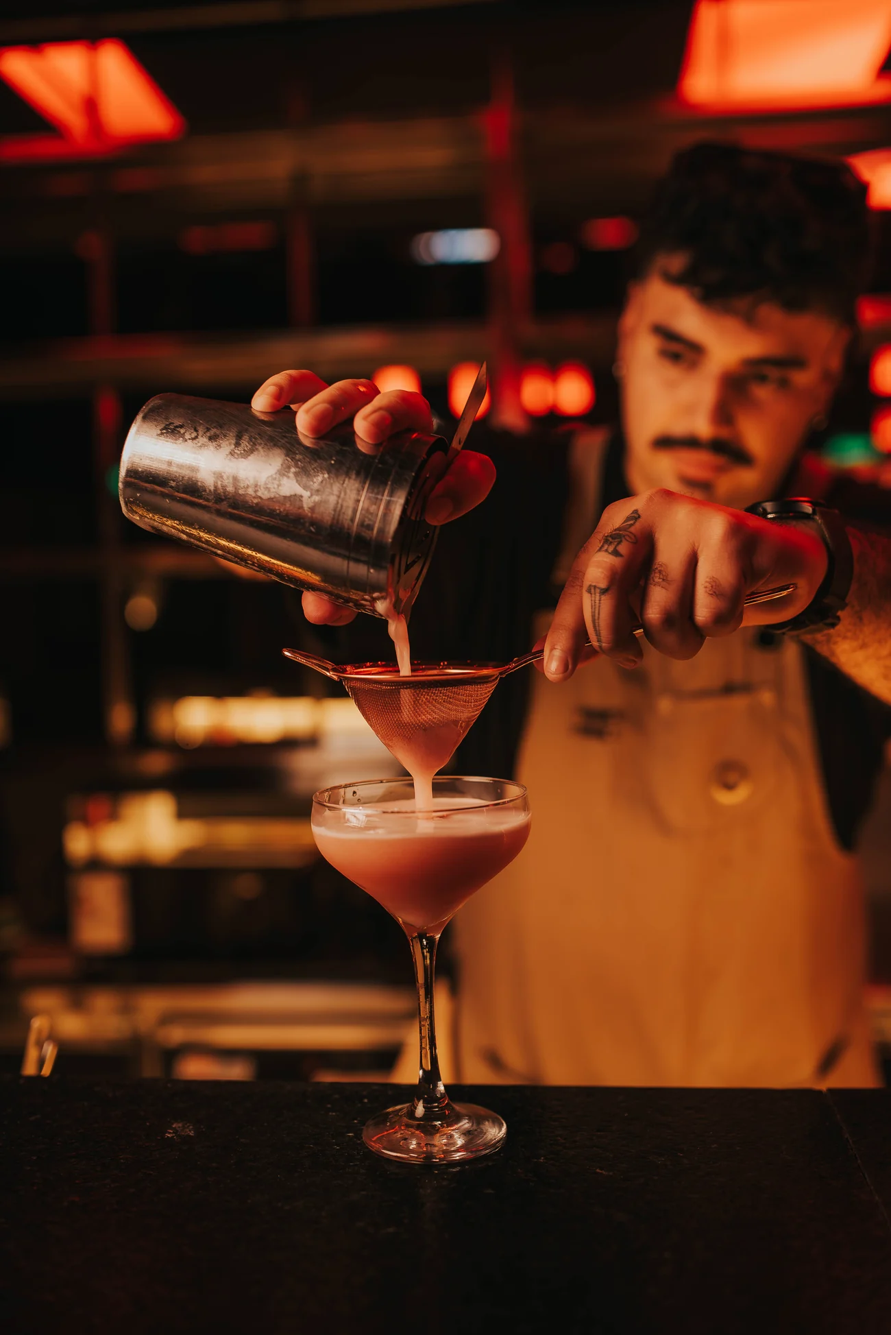 Bartender colando un cóctel